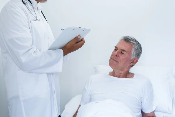 Male doctor writing medical report — Stock Photo, Image