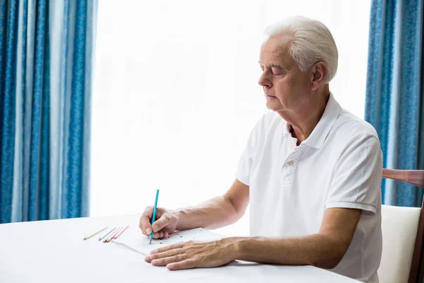 Homme âgé utilisant un livre à colorier — Photo