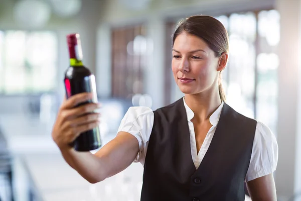 Cameriera in possesso di una bottiglia di vino — Foto Stock