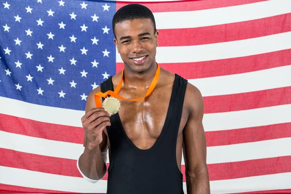Sportovec, ukazující jeho zlatou medaili před americkou vlajkou — Stock fotografie