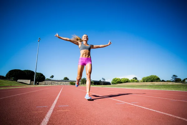 Spændt kvindelig atlet poserer efter en sejr - Stock-foto