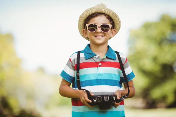 Menino em óculos de sol segurando câmera — Fotografia de Stock