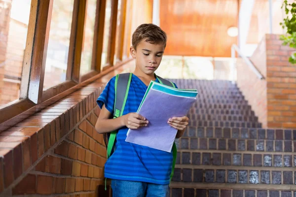 Schoolboy reading book on staircase — Stock Photo, Image