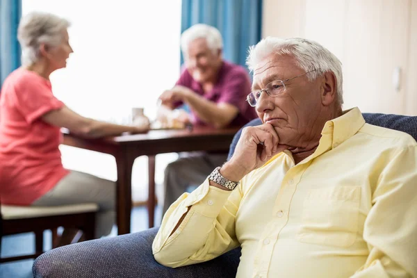 Senior sitter på en soffa — Stockfoto