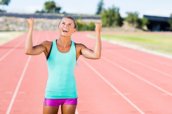 Lykkelig kvinnelig idrettsutøver som poserer etter en seier – stockfoto