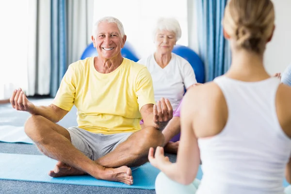 Instruktör utför yoga med seniorer — Stockfoto