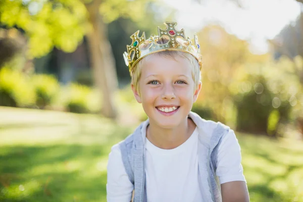 王冠を身に着けていると、公園に笑みを浮かべて少年 — ストック写真