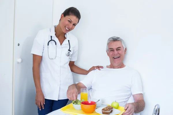 Anziano e medico donna sorridente in ospedale — Foto Stock