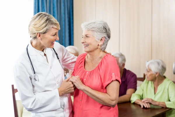 Verpleegkundige en senior vrouw knuffelen — Stockfoto