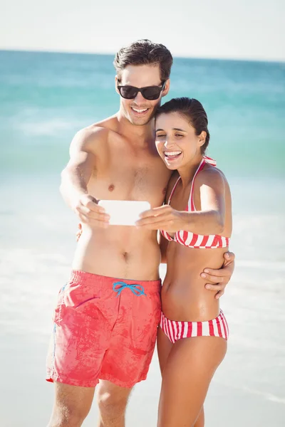 Ungt par med selfie på stranden — Stockfoto