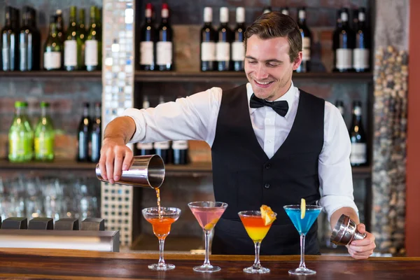Barman nalévali pití oranžové martini sklenice — Stock fotografie