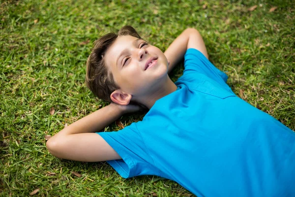 Young boy lying on grass — Stockfoto