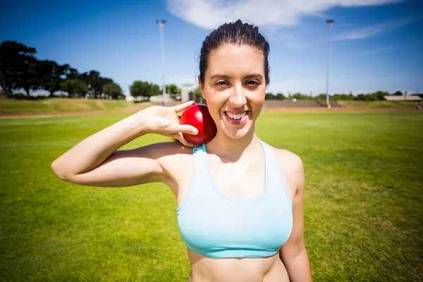 Portrait of female athlete preparing to throw shot put ball — Stock Photo, Image