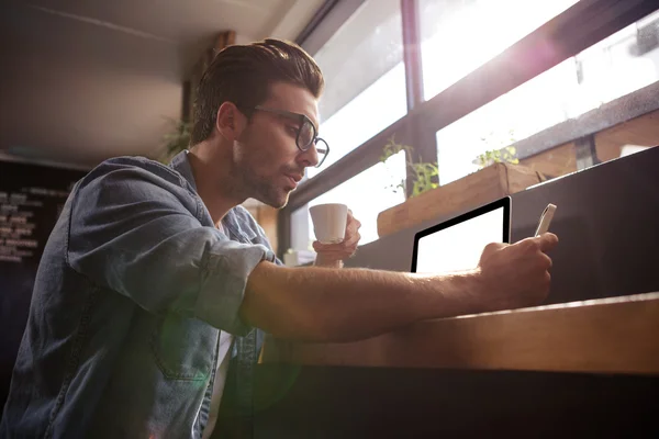 Homme buvant du café et utilisant un smartphone — Photo