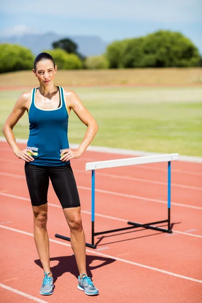 Porträt einer Sportlerin, die mit den Händen auf den Hüften steht — Stockfoto