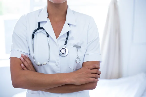 Mid-section of female doctor standing with arms crossed — Stock Photo, Image