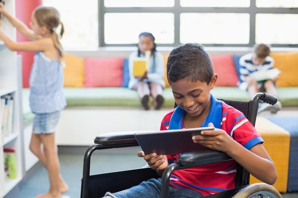 Skolpojke på rullstol med hjälp av Tablet PC — Stockfoto