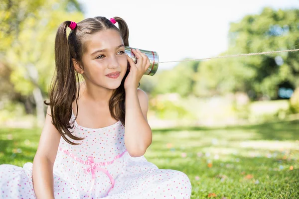 Menina ouvindo através lata telefone — Fotografia de Stock