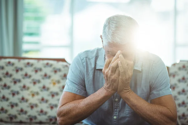 Bezorgd senior man zit in de woonkamer — Stockfoto