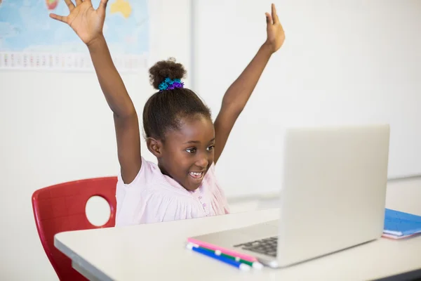 Schoolgirl with laptop in classroom — Stock Photo, Image