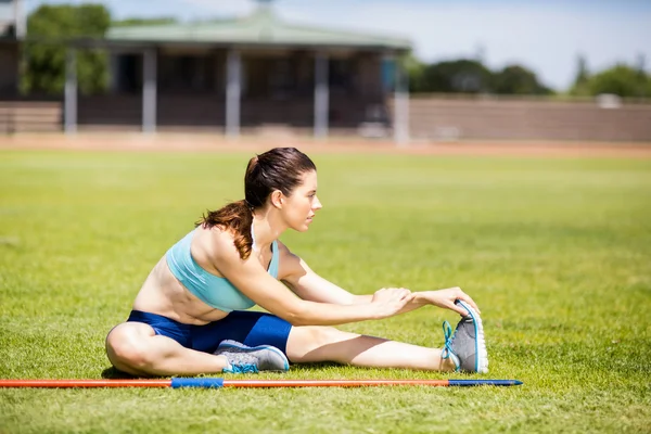 Female athlete warming up in stadium — Stock Photo, Image