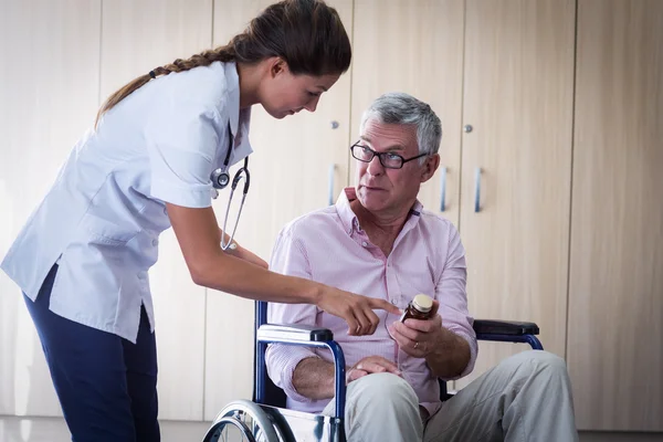 Médico feminino dando remédio para homem idoso — Fotografia de Stock
