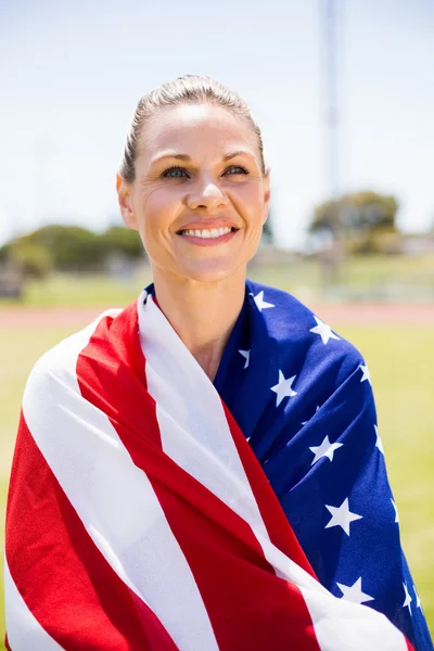 Šťastné ženy sportovec zabalené v americké vlajky — Stock fotografie