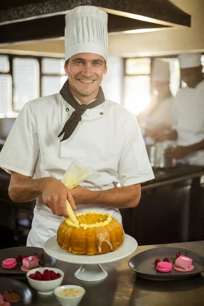 Chef sonriente piping glaseado en pastel —  Fotos de Stock
