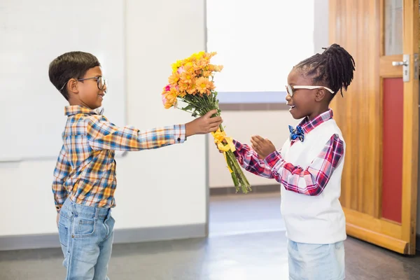 Школьник дарит цветы девушке — стоковое фото