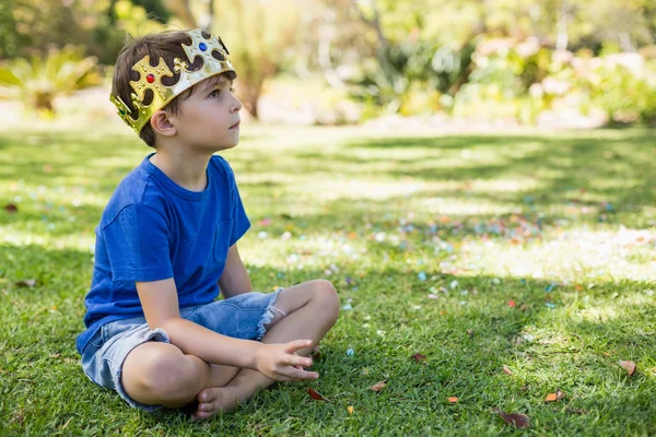 Young boy sitting in park — Stock Photo, Image