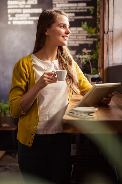 Женщина пьет кофе с помощью планшета — стоковое фото