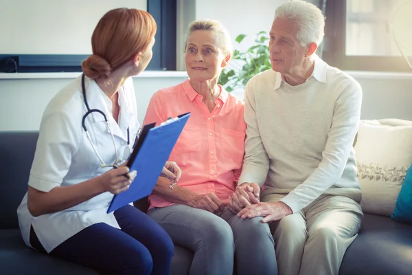 Doctor and senior couple interacting with each other — Stock Photo, Image