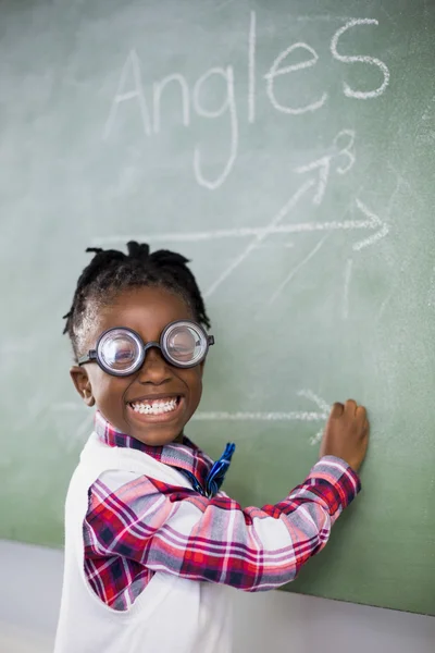 Colegiala haciendo matemáticas en pizarra —  Fotos de Stock