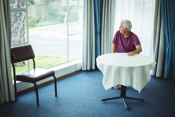 Senior man sitting in living room — Stock Photo, Image