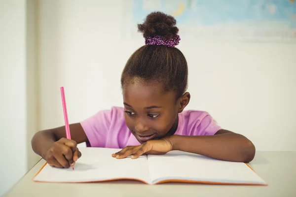 Iskola lány csinál házi feladatot osztályteremben — Stock Fotó