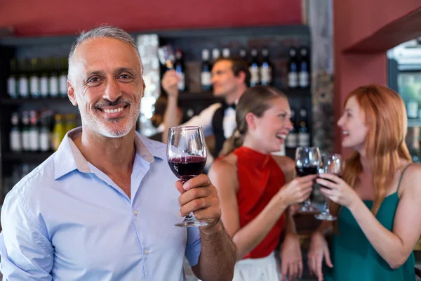 Homem sorridente segurando copo de vinho — Fotografia de Stock