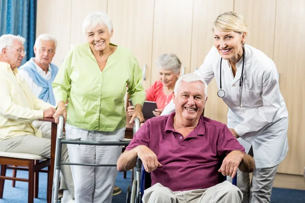 Seniors with wheelchair and walking aid — Stock Photo, Image