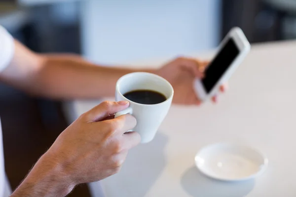 Mann trinkt Kaffee während er SMS schreibt — Stockfoto