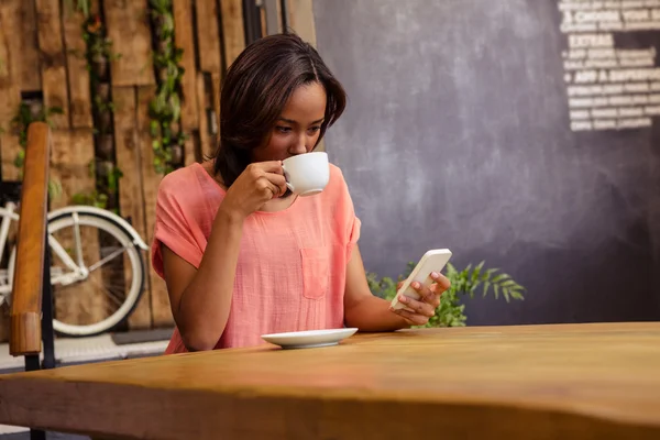 Femeia care bea cafea folosind smartphone-ul — Fotografie, imagine de stoc