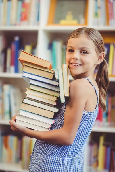 Chica de la escuela sosteniendo pila de libros — Foto de Stock