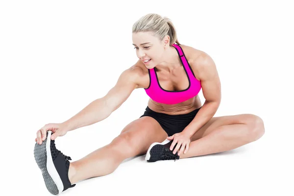 Female athlete sitting and stretching — Stock Photo, Image