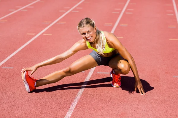 Kadın atlet koşu parkuru ısınmaya — Stok fotoğraf
