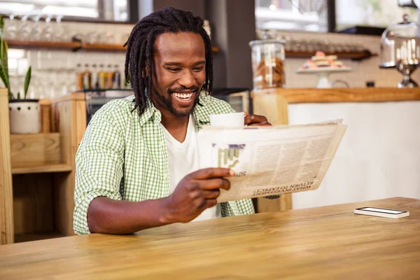 Hombre riendo cuando está leyendo el periódico — Foto de Stock