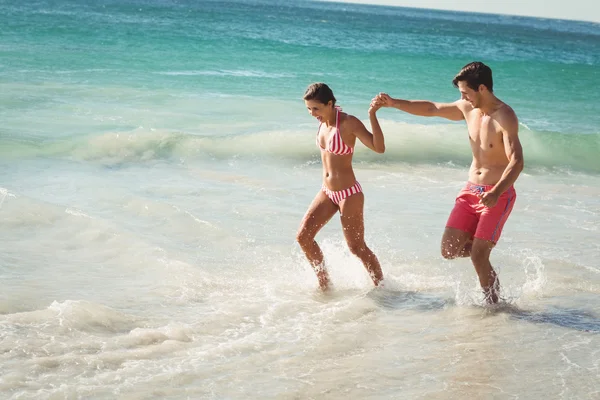 Pareja corriendo en el agua — Foto de Stock