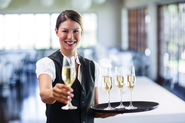 Servitrisen erbjuder glas champagne — Stockfoto