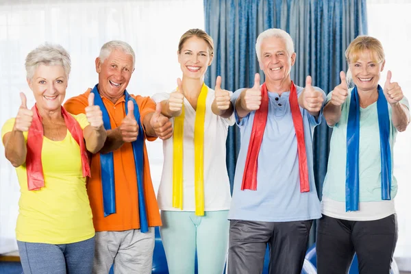 Instrutor e idosos com polegares para cima — Fotografia de Stock