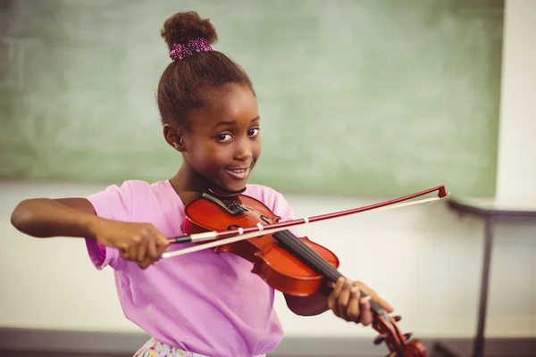 Smiling schoolgirl playing violin in classroom — Stock Photo, Image