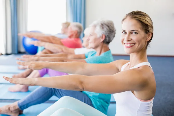 Instructor performing yoga with seniors