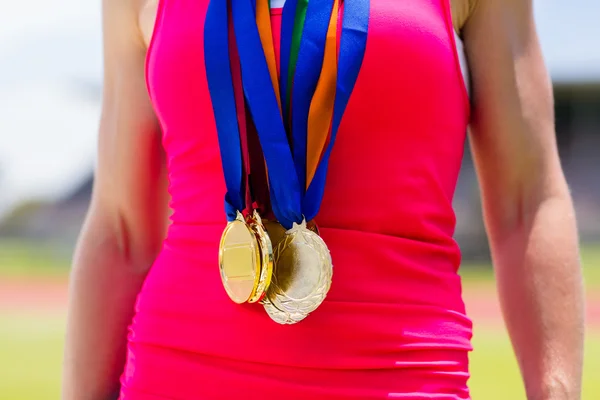 Sección media de la atleta femenina con medallas de oro —  Fotos de Stock