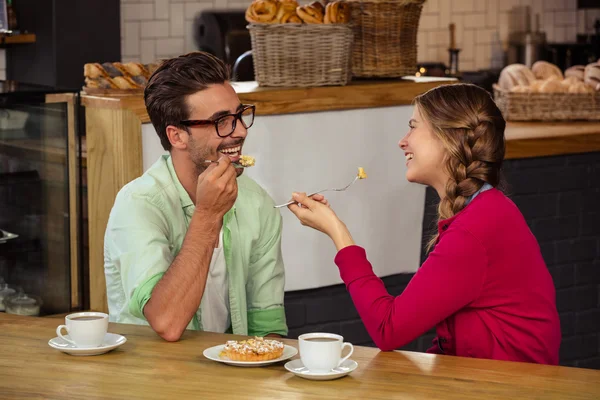 Coppia sorridente mangiare torta — Foto Stock